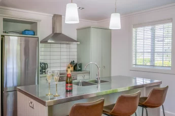Modern kitchen with new fridge and island bench, perfect for entertaining at Butterfly Cottage