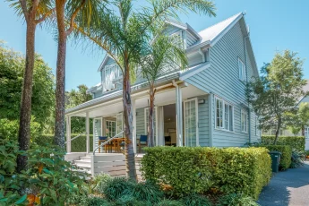 Two story Kingfisher Cottage with lush garden and Nikau Palms