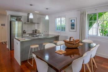 Modern kitchen with island bench and barstools, perfect for entertaining at Tinkerbell Cottage
