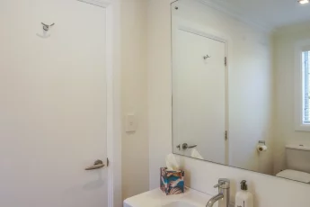 Vanity with large mirror in bathroom one at Capital Cottage