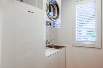 Fully equipped laundry, with washer, dryer laundry tub and additional fridge at Bellbird Cottage
